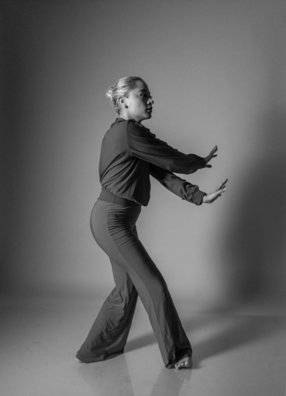 Woman performing a fluid cardio movement in a calm studio setting.